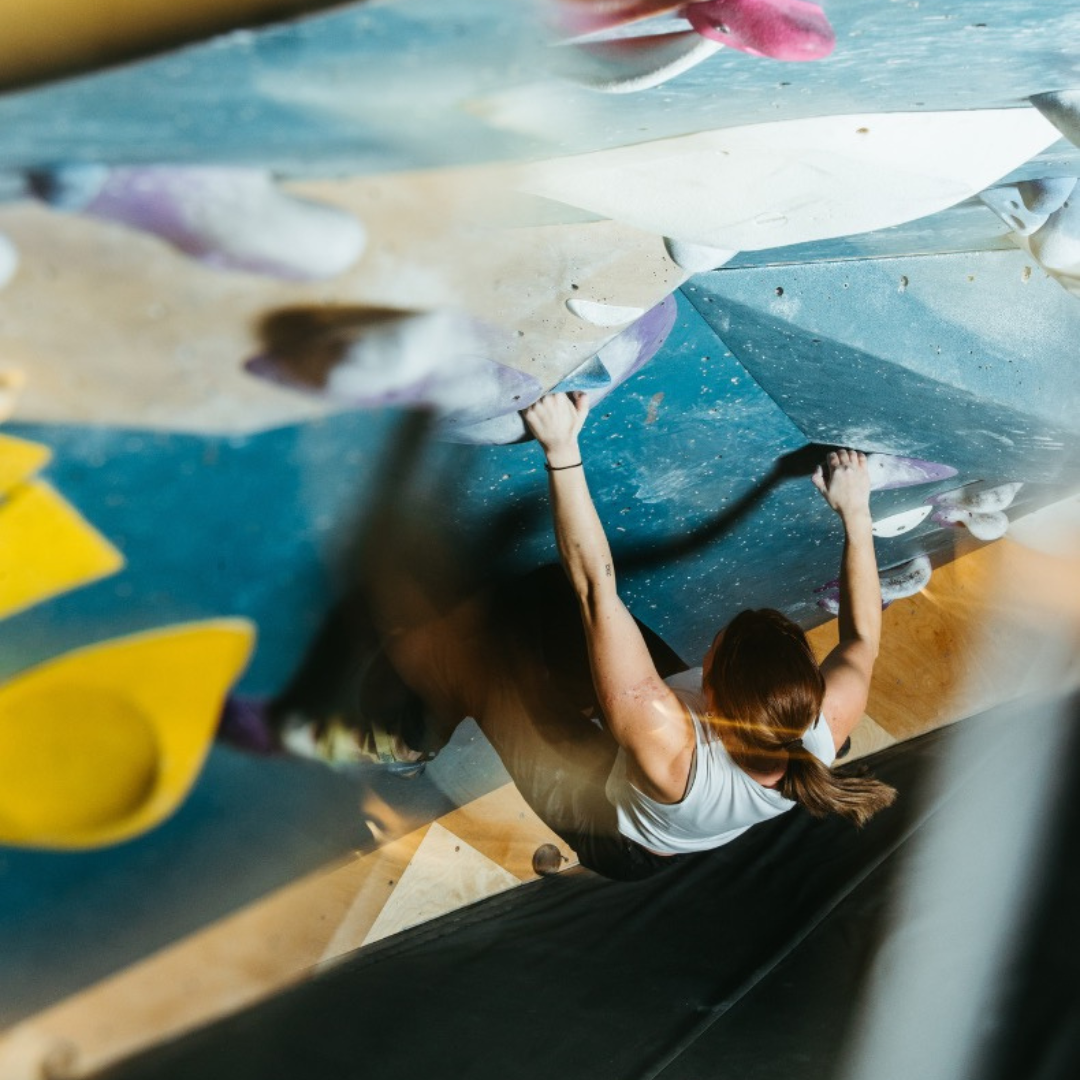 Woman climbing in an overhang cave at Bouldering Project
